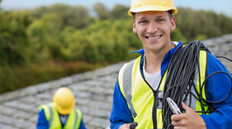 Handwerker trägt ein Seil über der Schulter